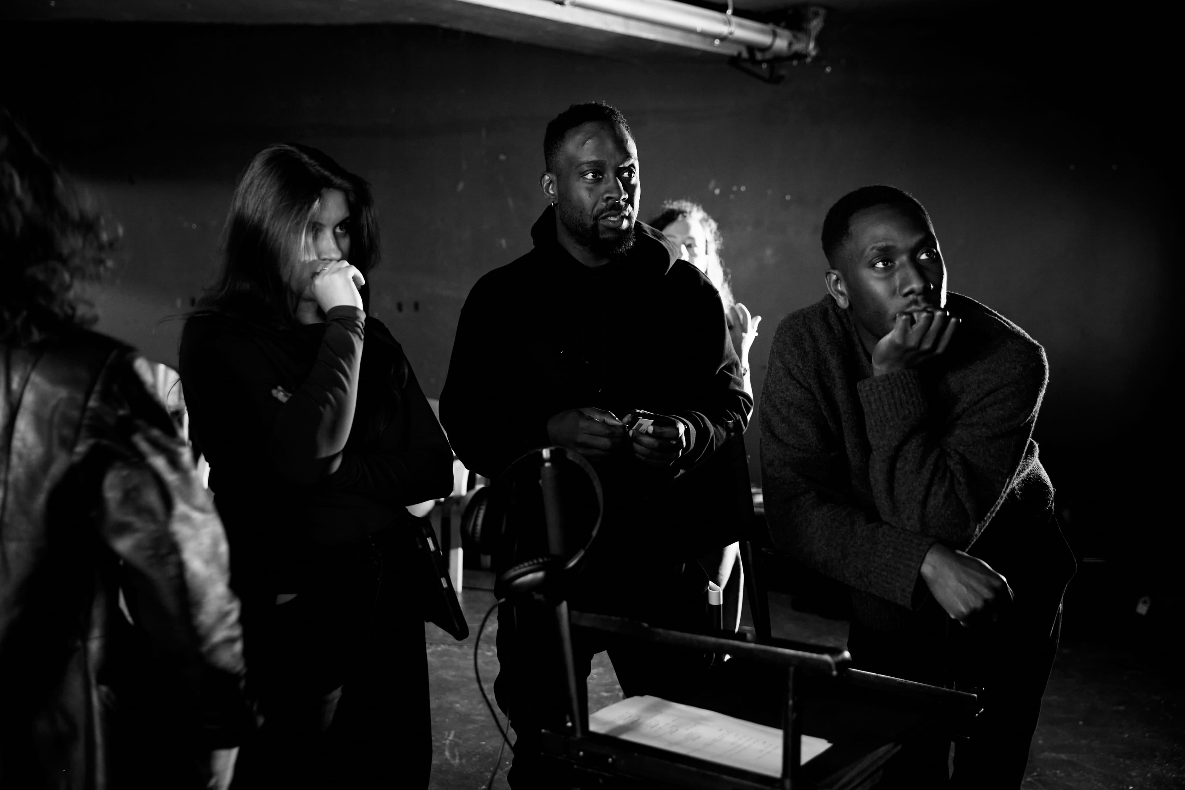 Gerald Gyimah on set with crew, reviewing the monitor